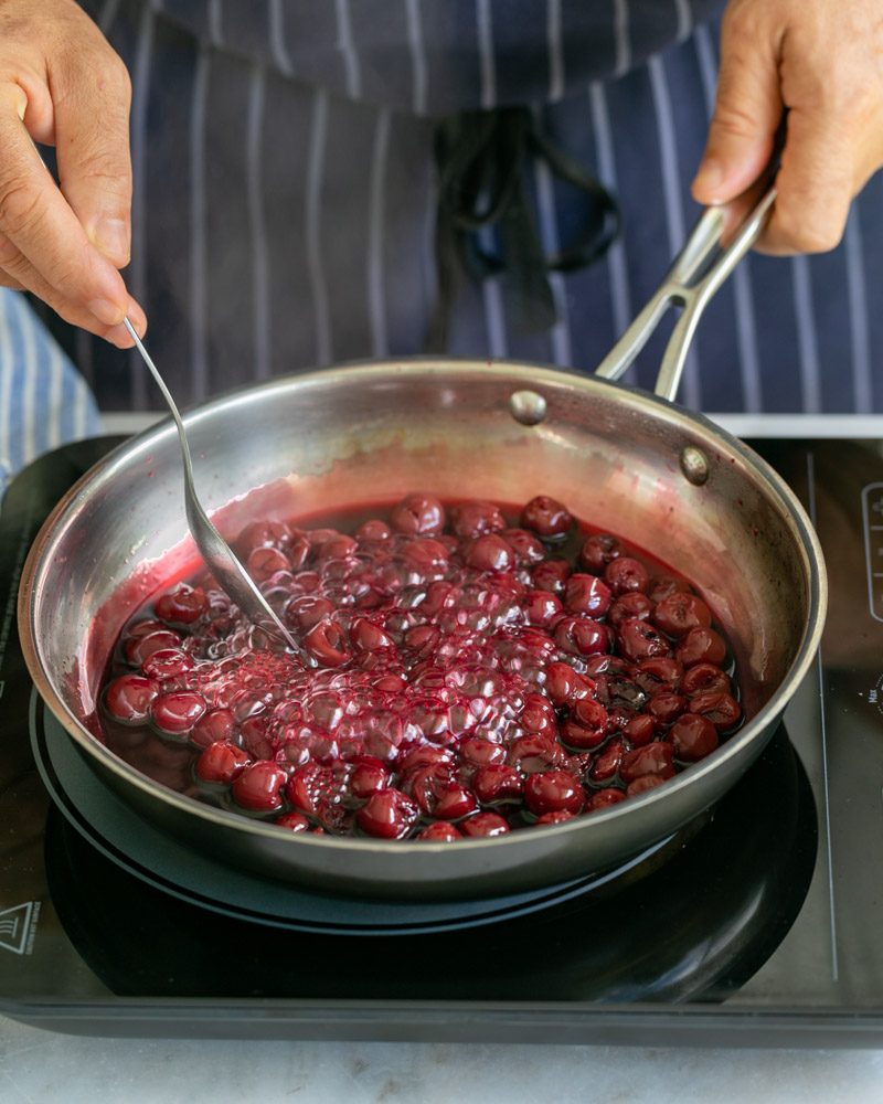 Cherries cooking in the bubbling syrup 