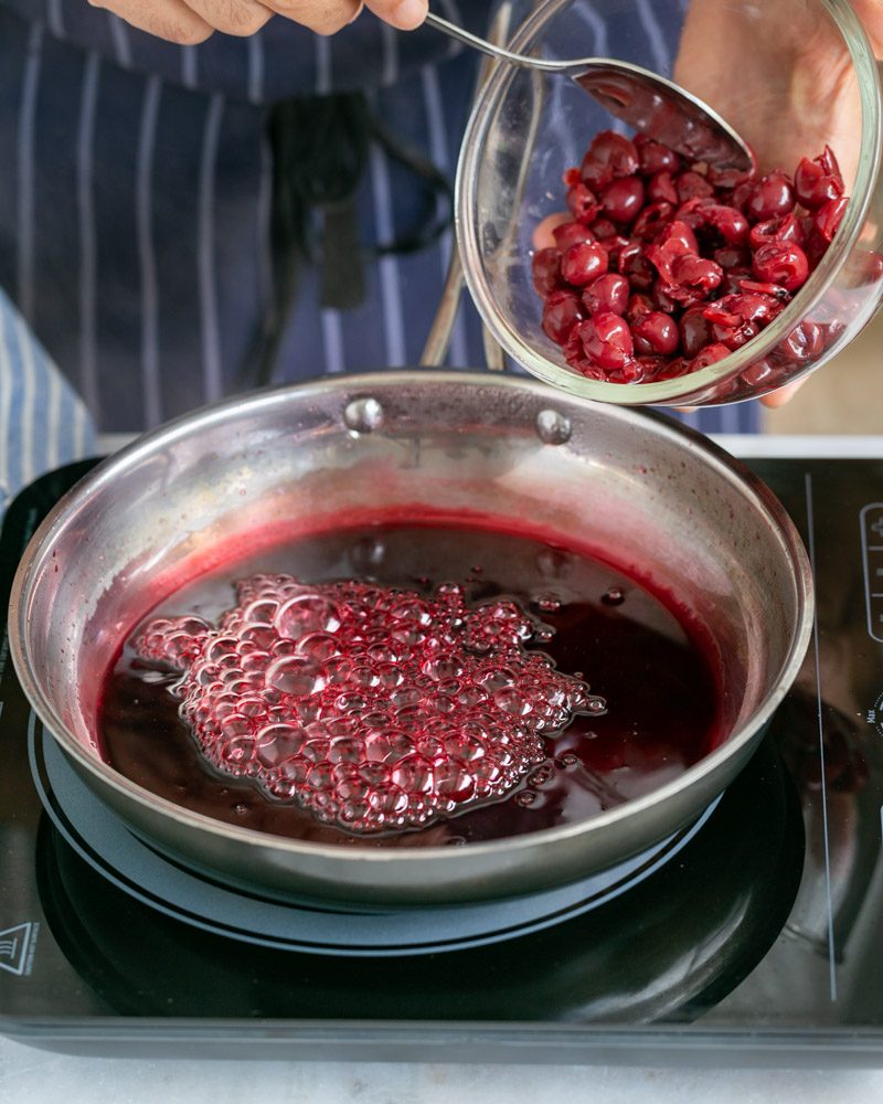 Cherries added to syrup in pan