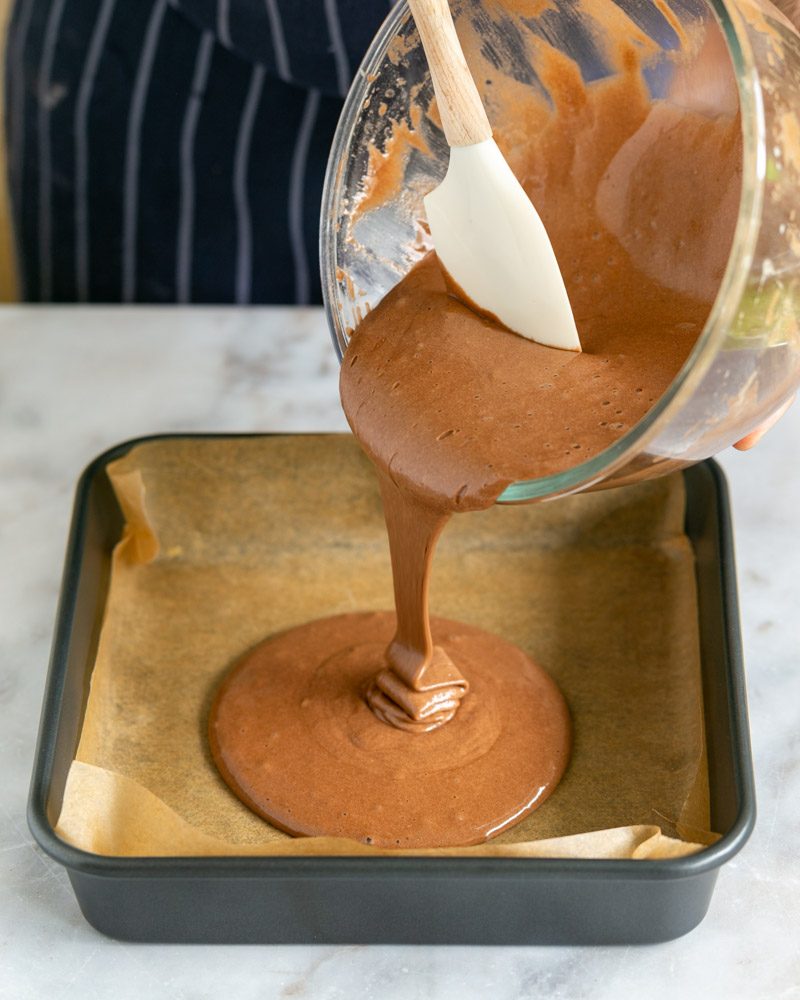 Chocolate sponge cake batter poured into baking pan