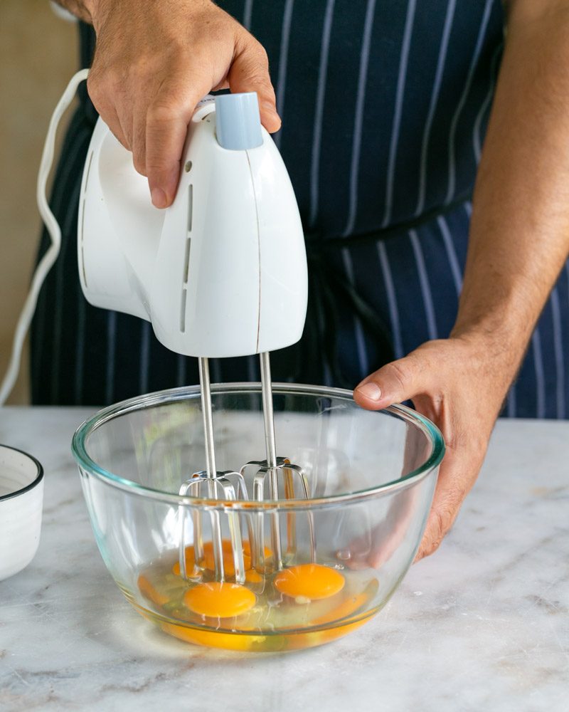 Eggs in a bowl with hand beater