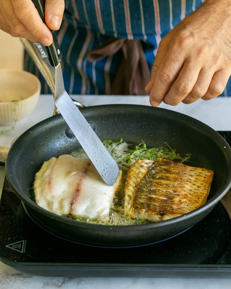 Turning the fish fillet in pan