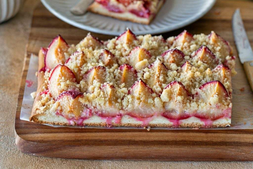 cut plum tart on a wooden board