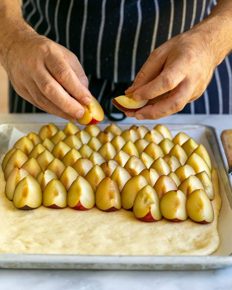 Layering the cake dough with plums