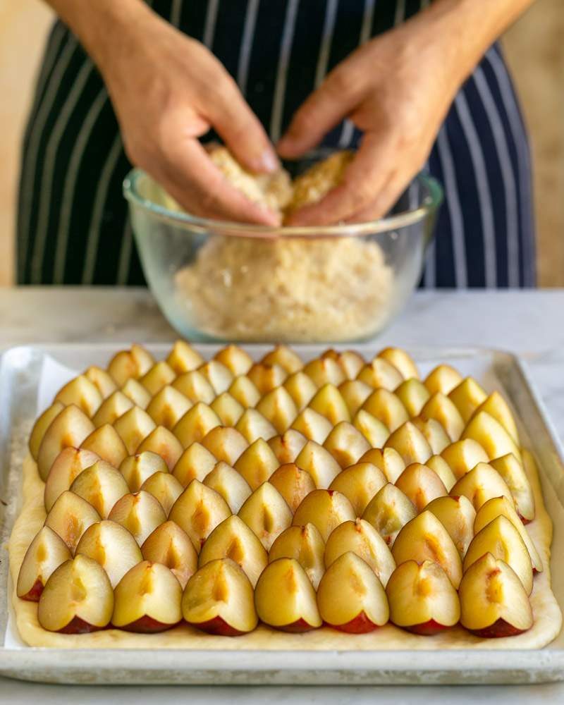 Sprinkling crumple on top of the layered plums