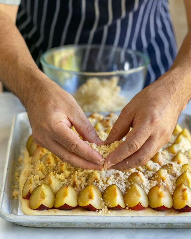 Sprinkling crumble over the plums