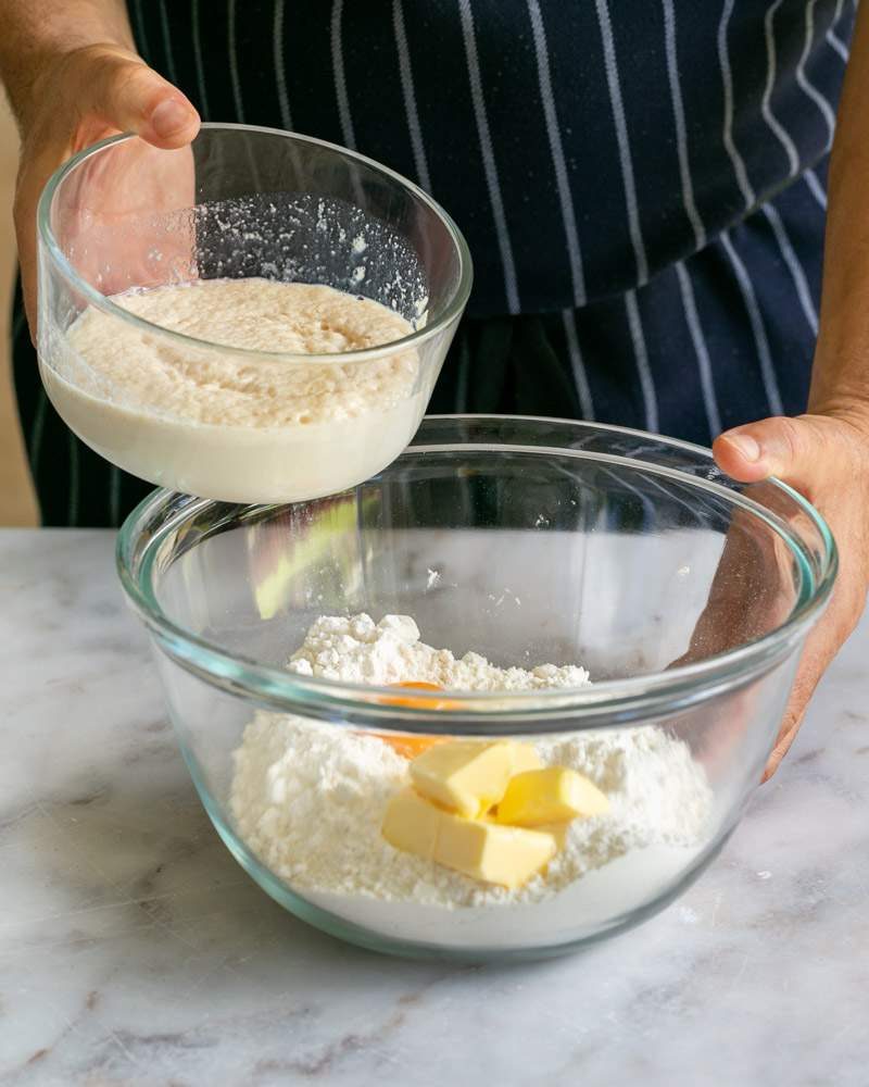 Adding yeast mixture to flour, butter egg yolk, and salt to make dough
