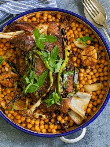Cooked Lamb Shoulder Roast in a round pan with chickpeas