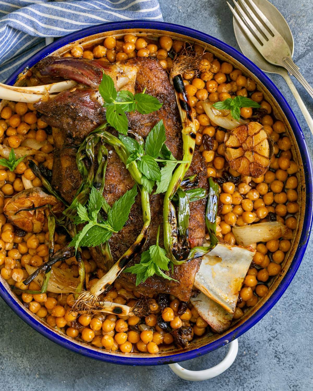 Cooked Lamb Shoulder Roast in a round pan with chickpeas