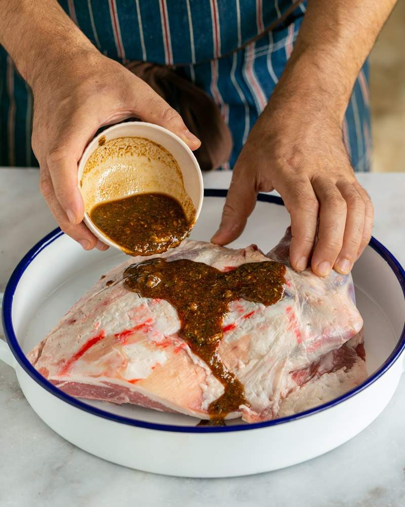 Pouring the marinade over the lamb shoulder