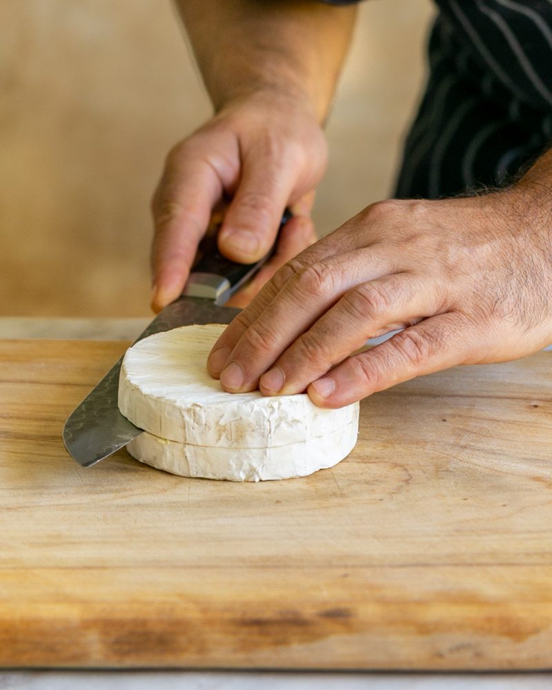 Cutting the brie round into two halves