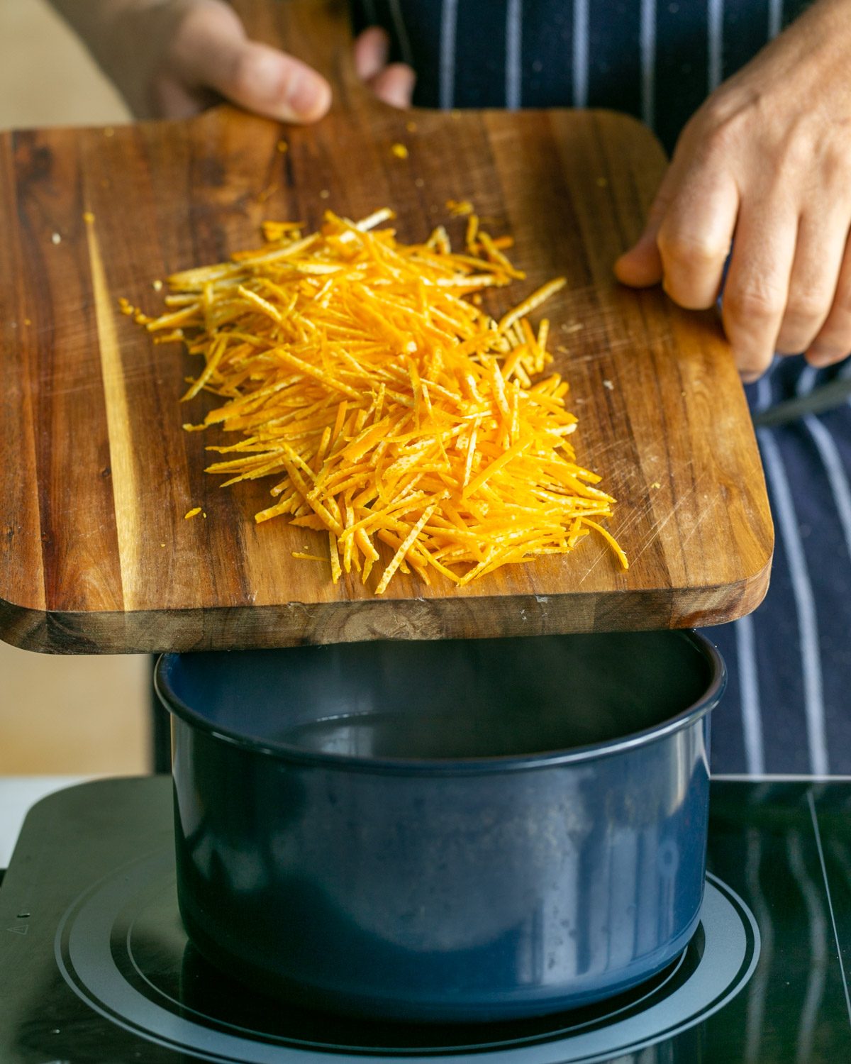 Adding the mandarin peel juliennes to boiling water