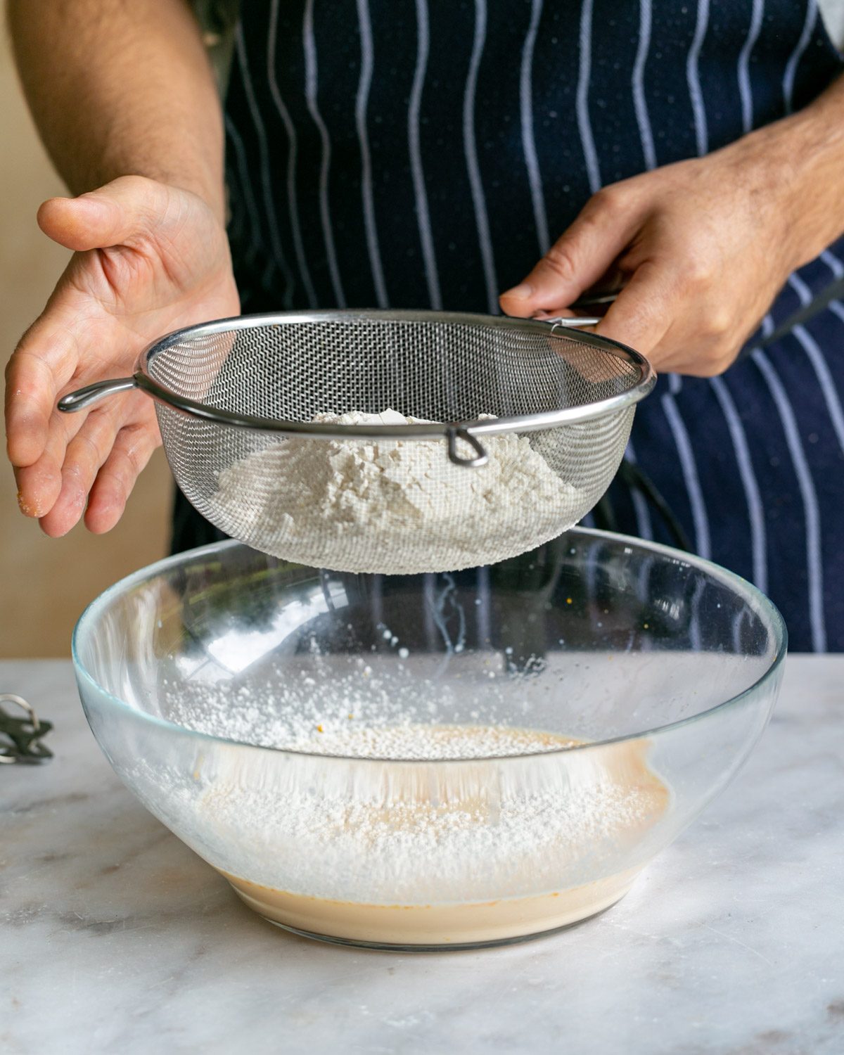 Sifting flour into crepe batter