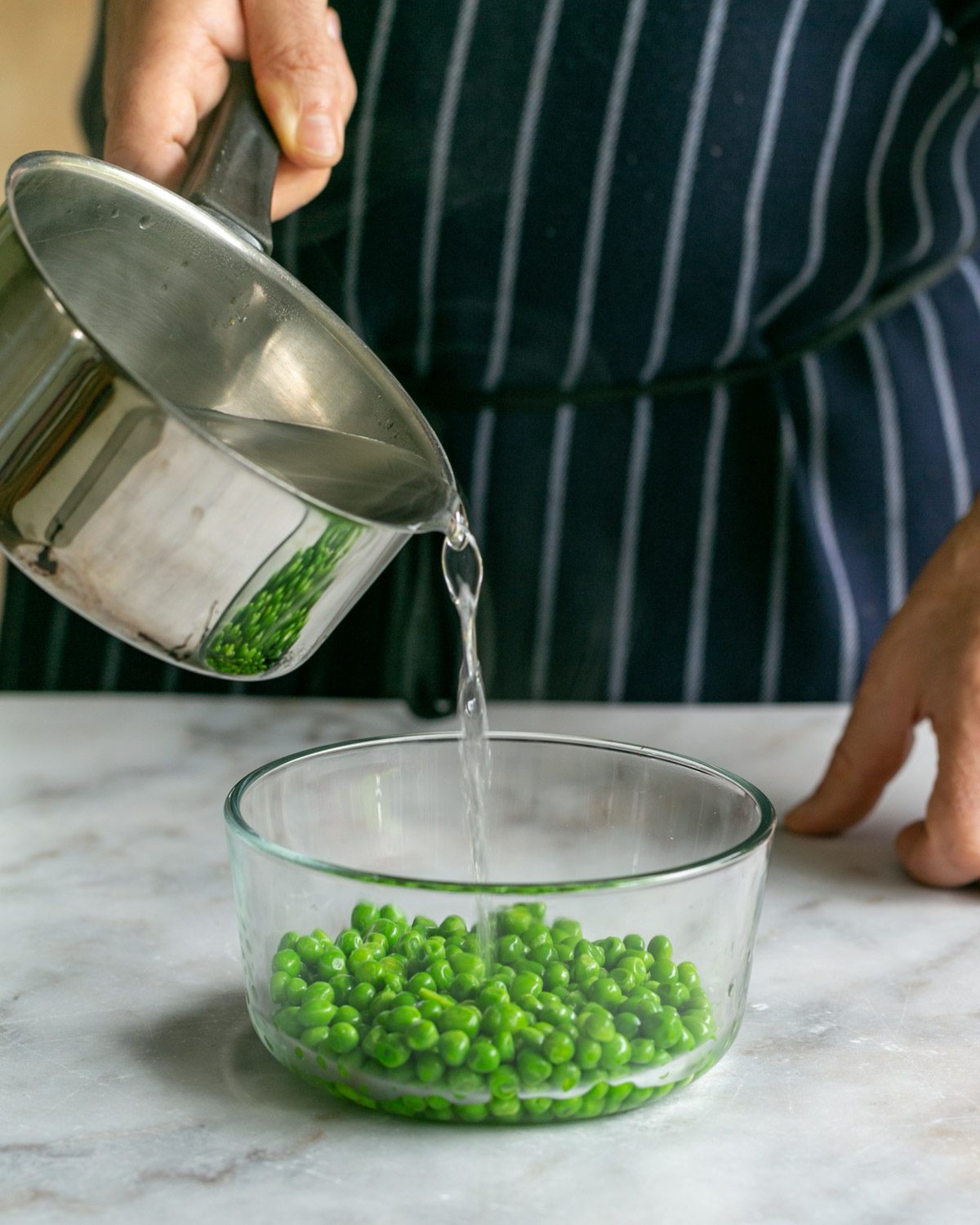 Pouring boiling water on frozen peas to keep them green