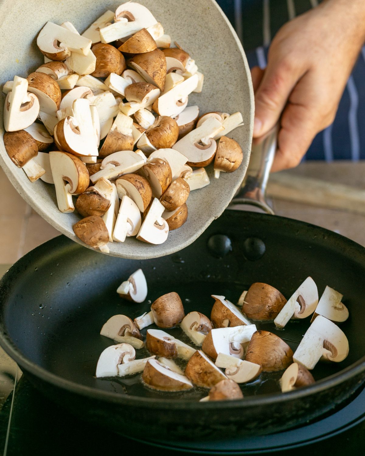 Adding mushrooms to a hot pan