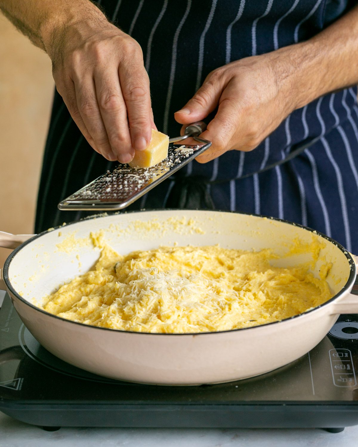 Grating cheese into cooked polenta
