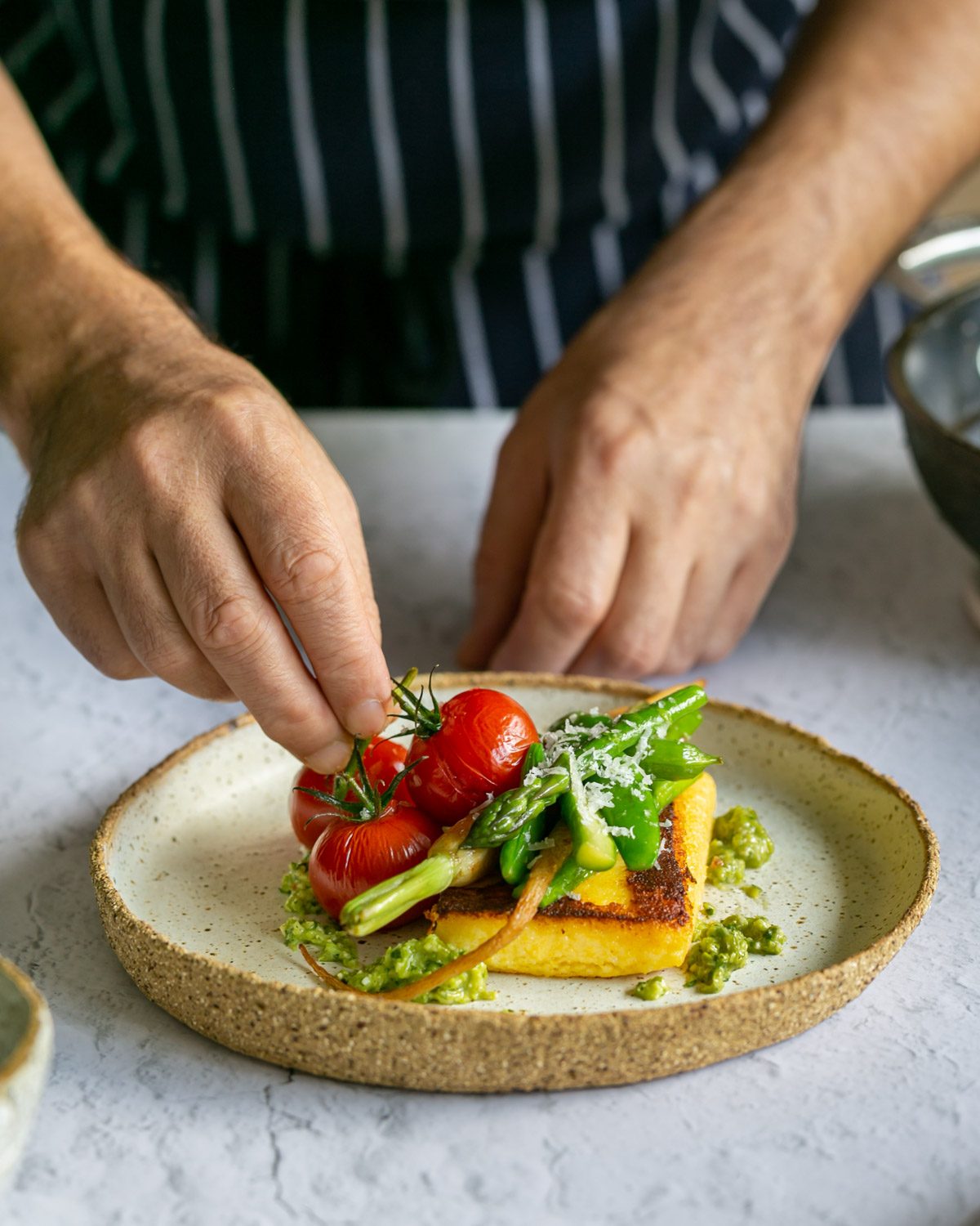 Plating up the polenta with vegetables on a plate