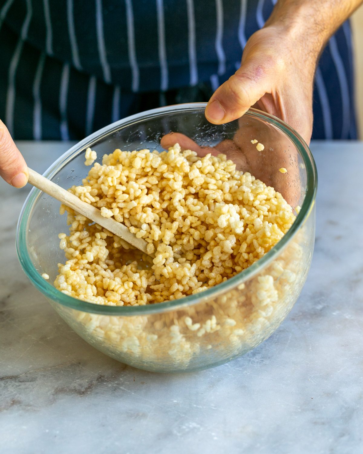 Mixing sugar syrup with puffed rice in a bowl