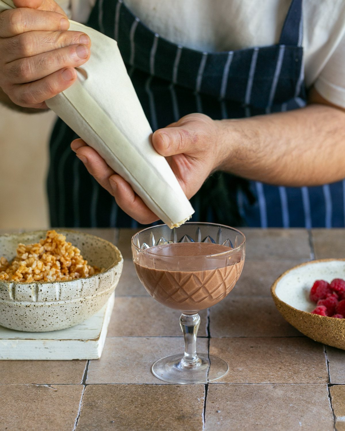 decorating dessert with whipped cream and caramelised puffed rice