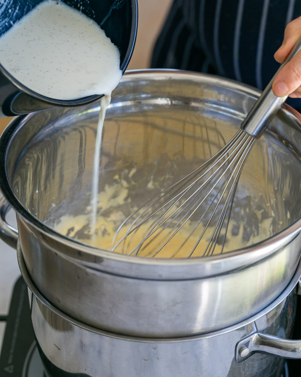 pouring vanilla milk to egg sugar mix