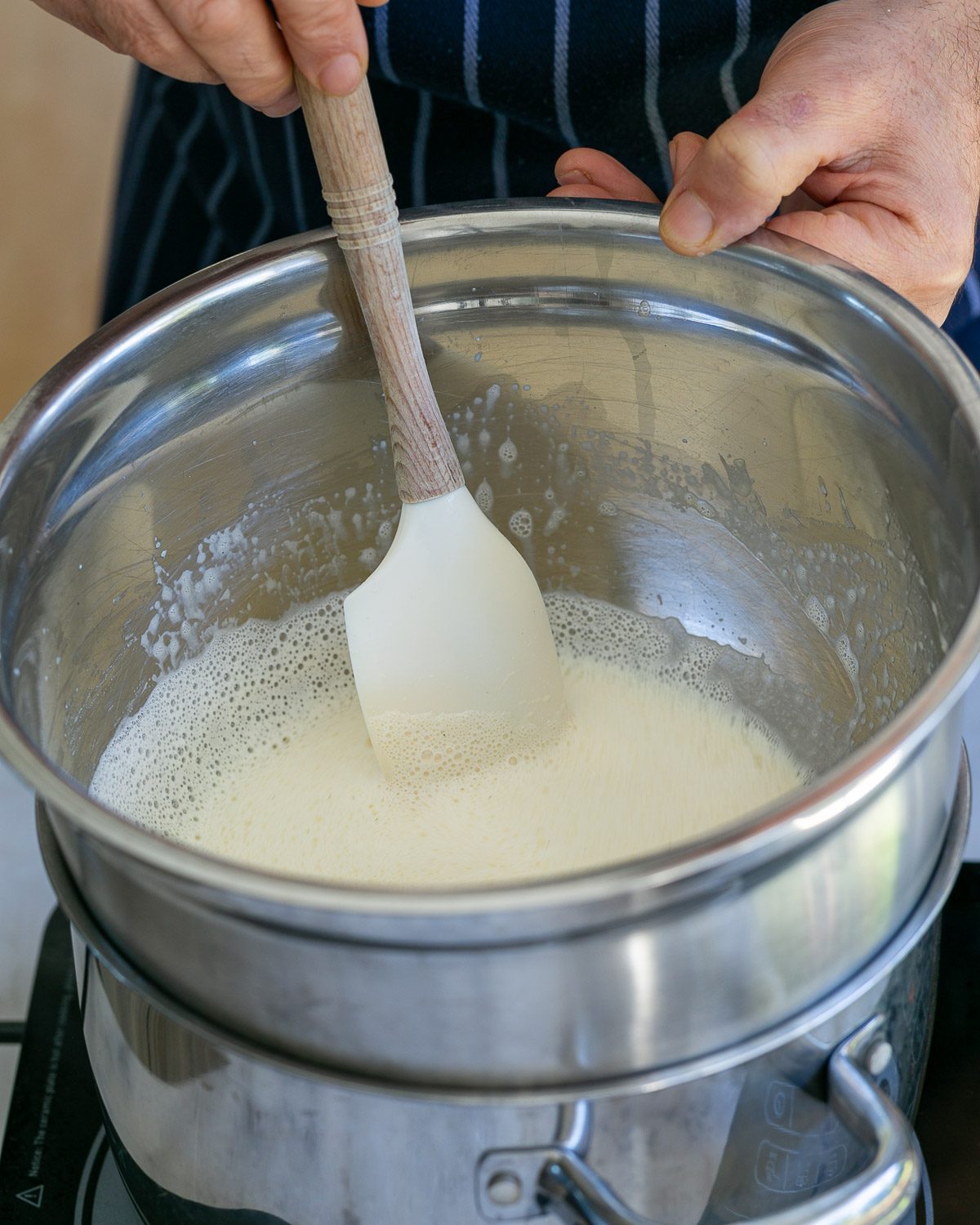 Egg yolk sugar mixture with vanilla milk in a bowl