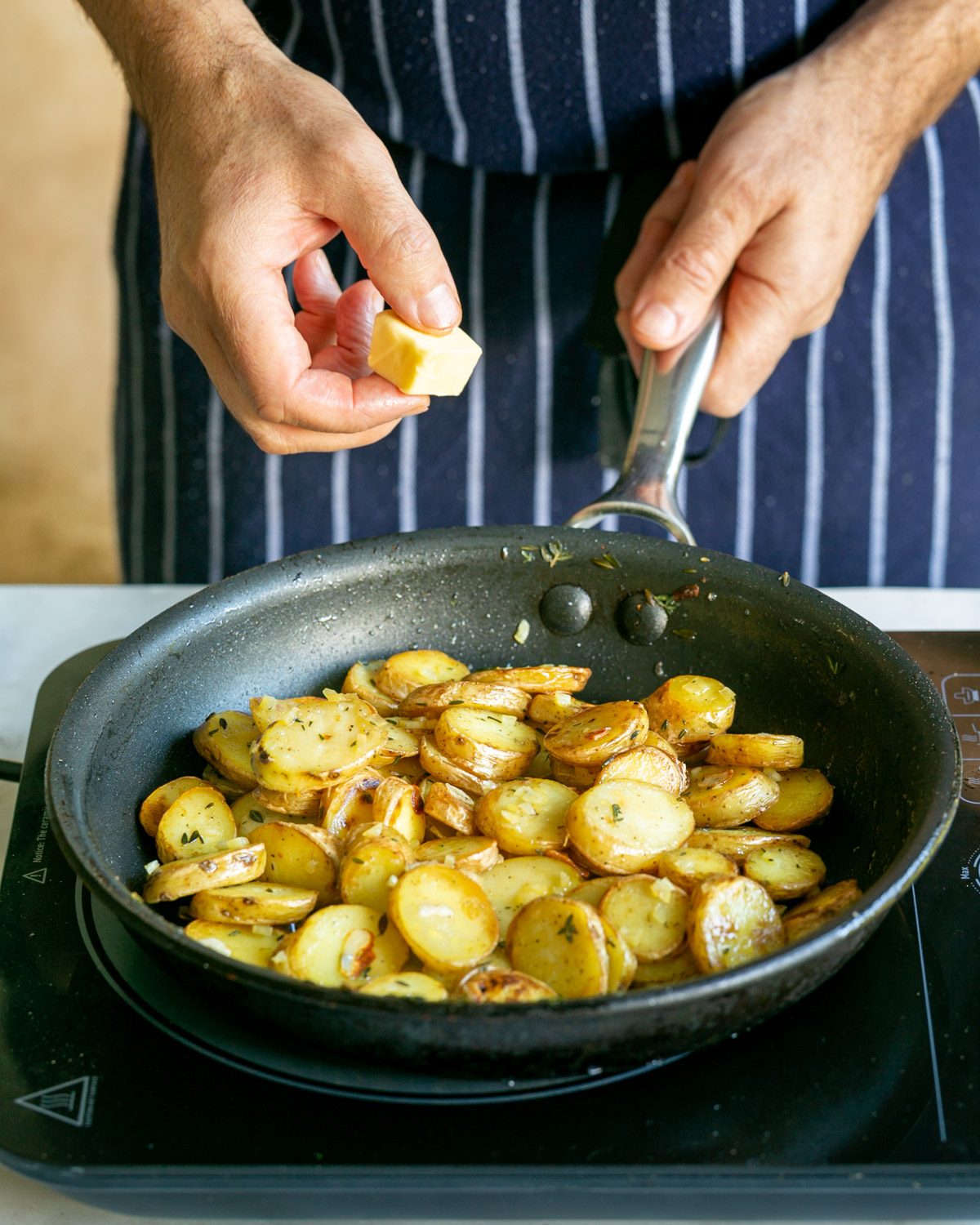 Adding butter to the kipfler potatoes