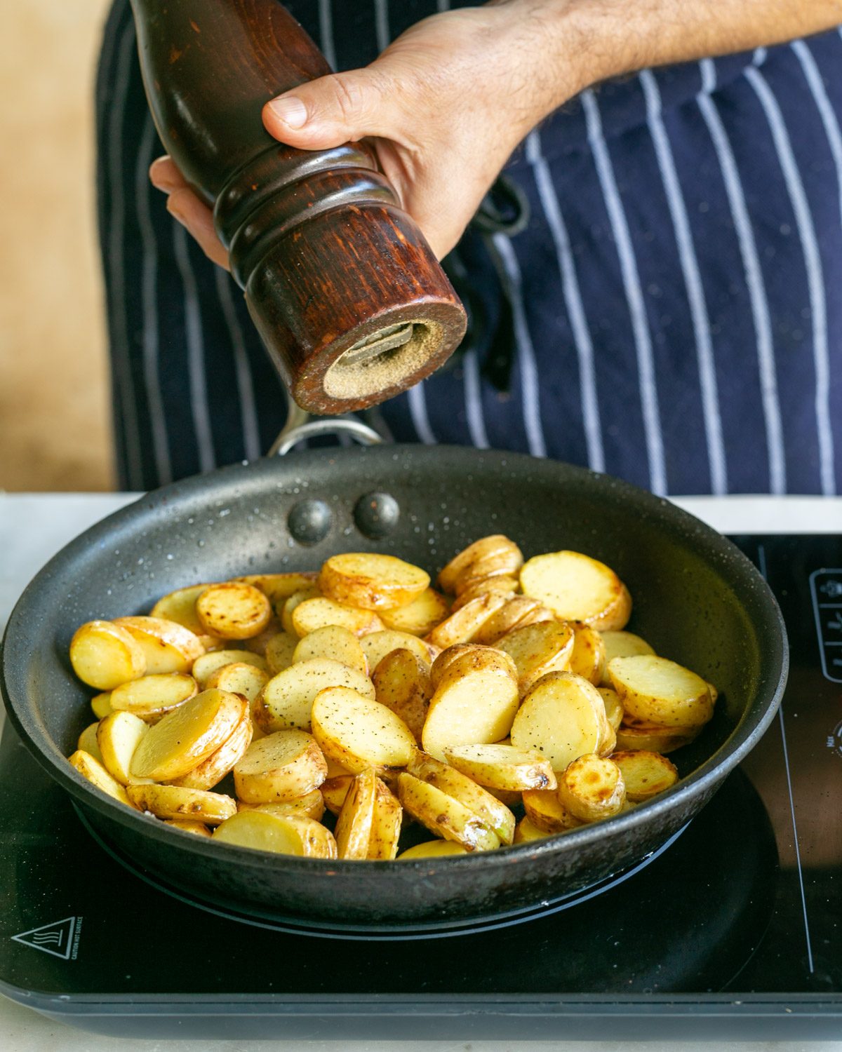 Adding pepper to roasted potatoes