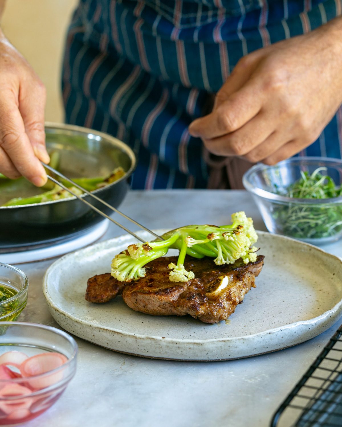 Plating up the lamb chops with cauli blossom