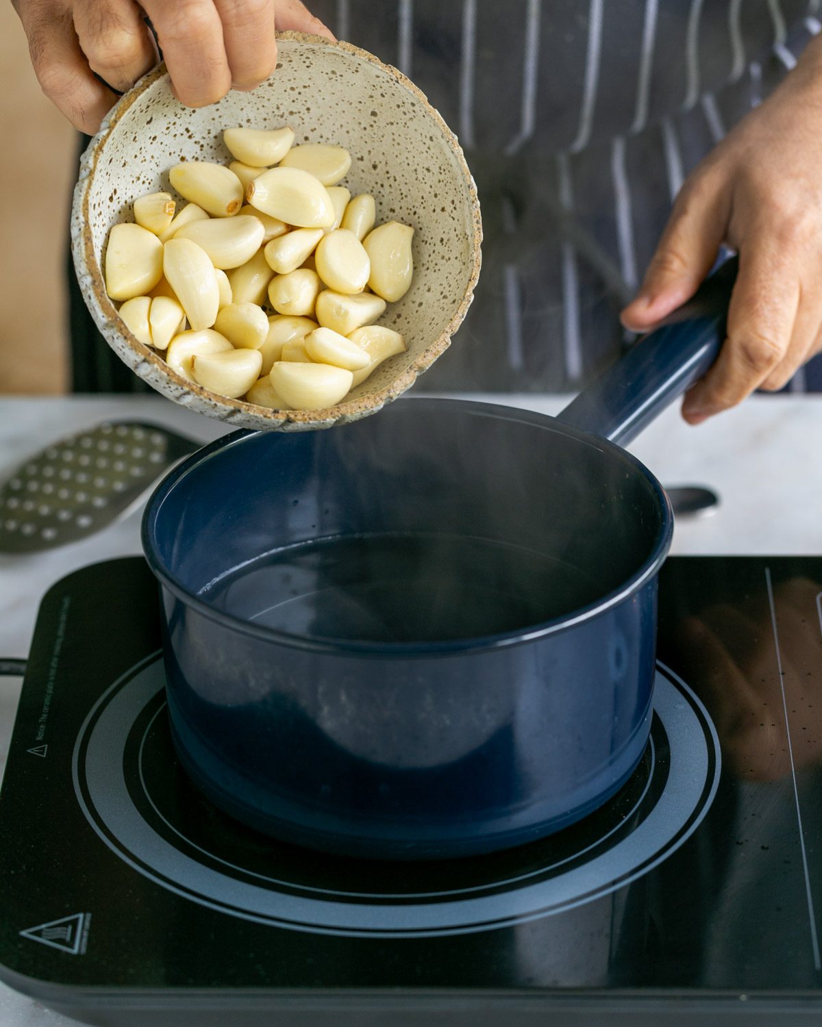Boiling garlic cloves in a pot