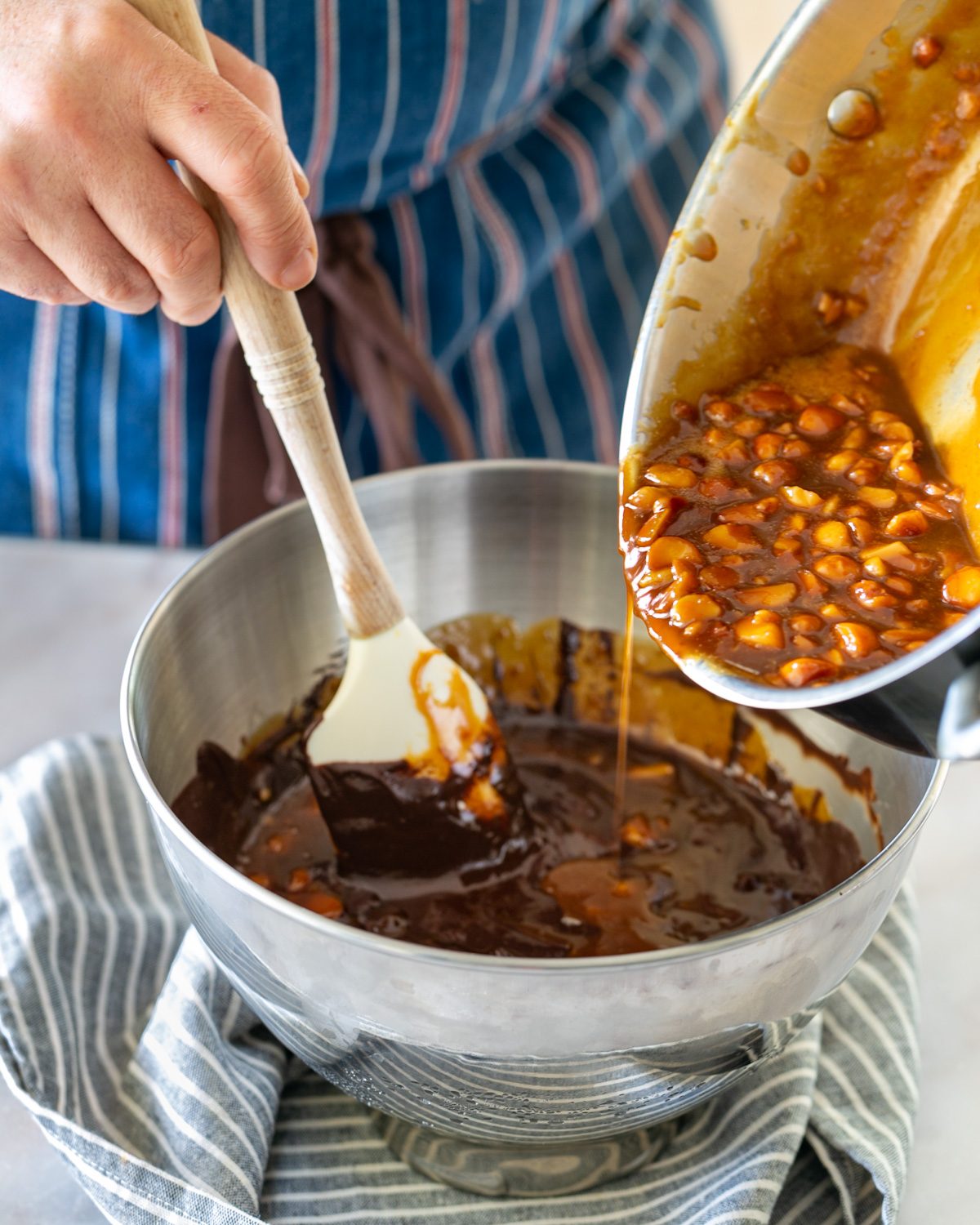 Adding caramel macadamia to the melted chocolate