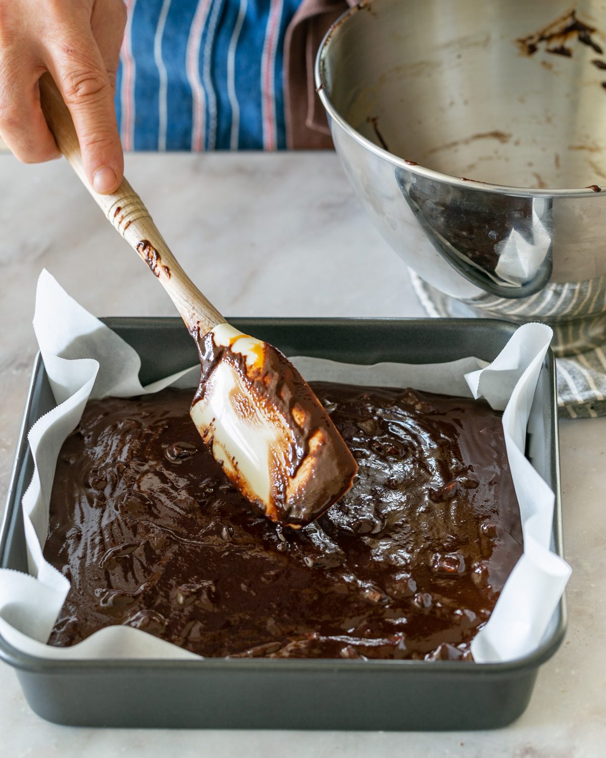 Pouring macadamia caramel and chocolate mix to baking pan