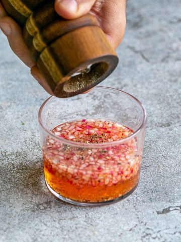 Adding cracked black pepper to the mignonette