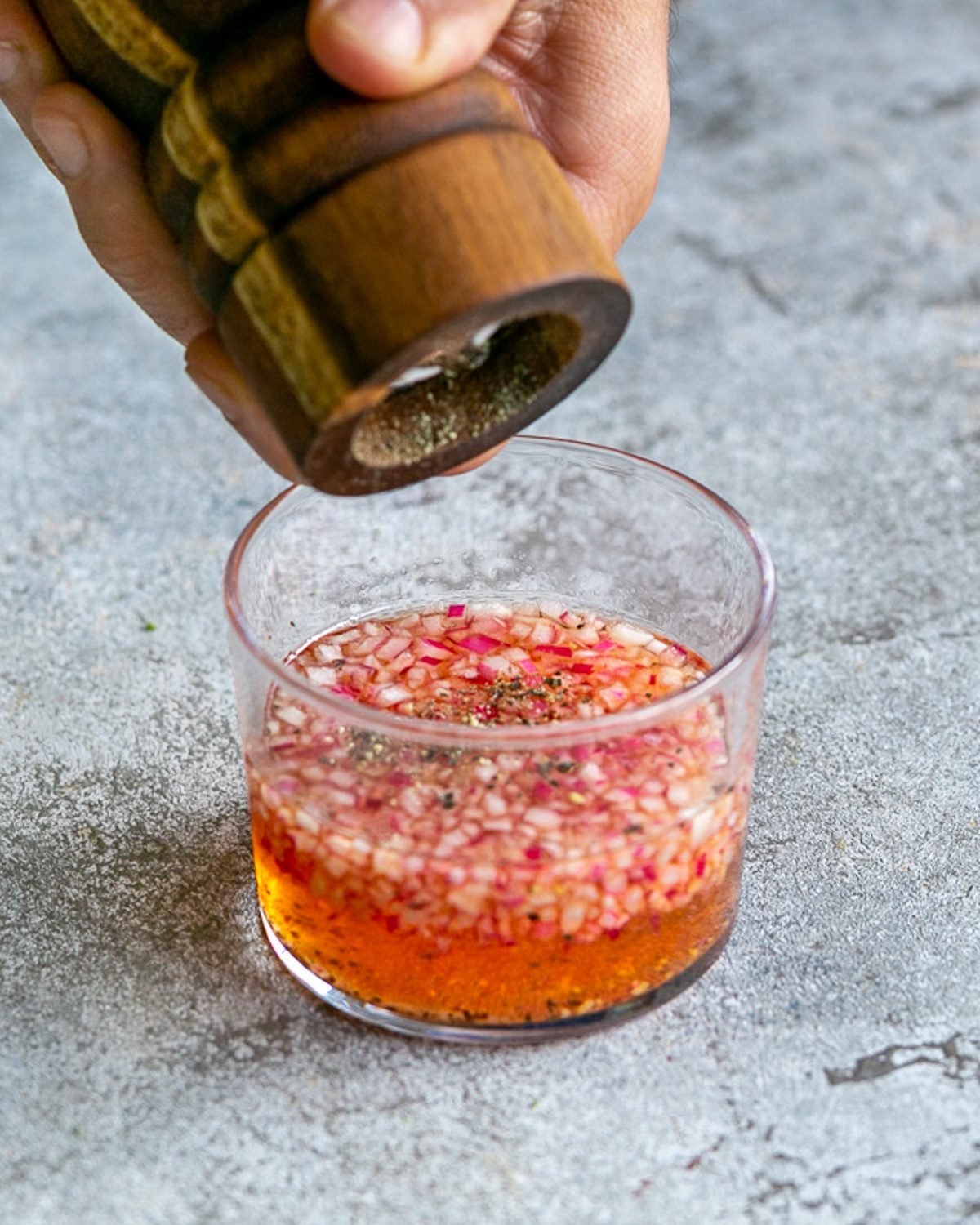 Adding cracked black pepper to the mignonette