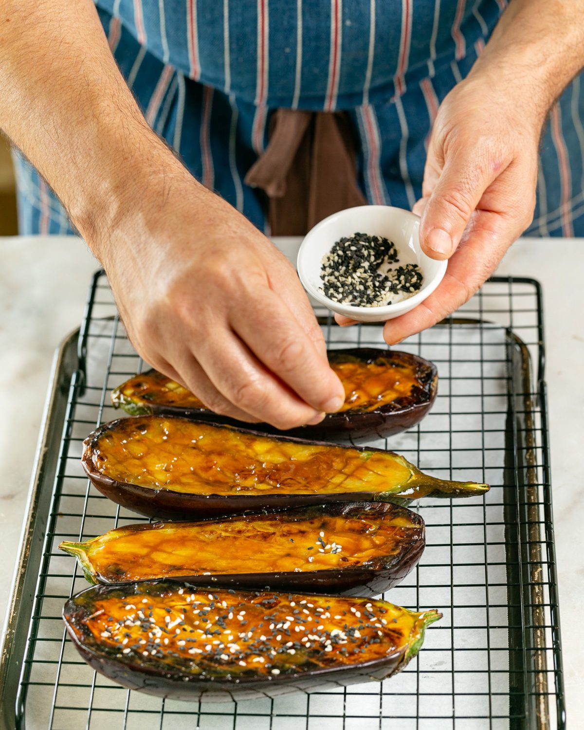 Sprinkling sesame seeds on eggplant